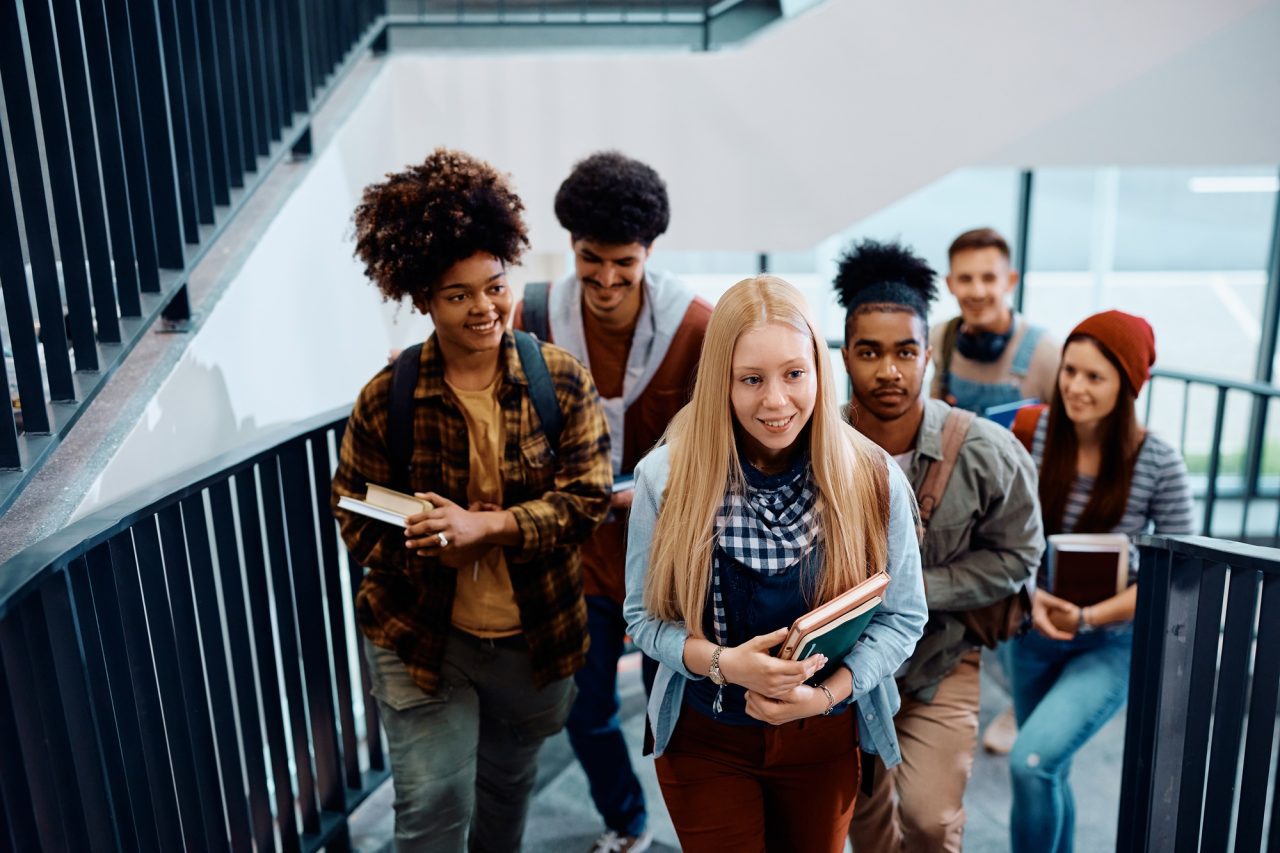 happy-student-and-her-classmates-at-university-hallway-.jpg
